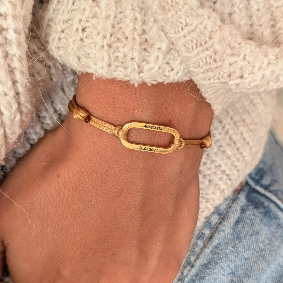 Bracelet personnalisé femme avec médaille anneau ovale gravée en acier inoxydable doré sur cordon satiné doré