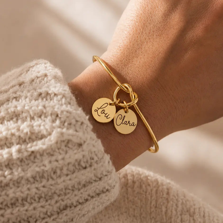 Bracelet jonc nœud doré ouvert médailles gravées prénoms personnalisé porté au poignet Bliche