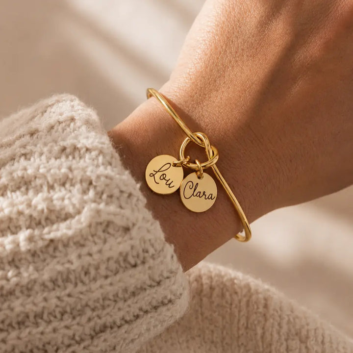 Bracelet jonc nœud doré ouvert médailles gravées prénoms personnalisé porté au poignet Bliche