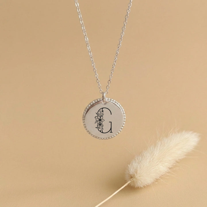 Collier femme médaille travaillée argentée à bordure perlée gravée initiale florale G, chaîne fine