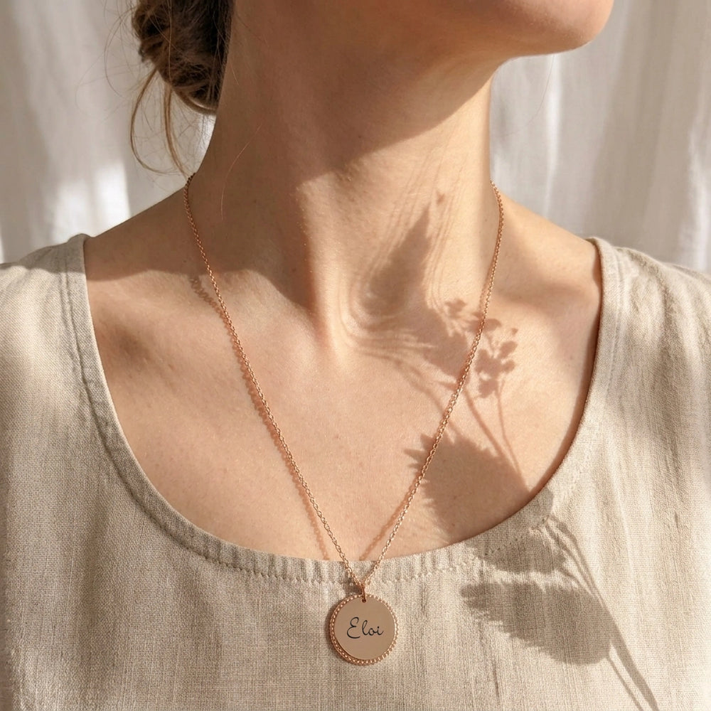 Collier femme médaille travaillée or rose gravée prénom Eloi porté au décolleté, chaîne fine 47 cm