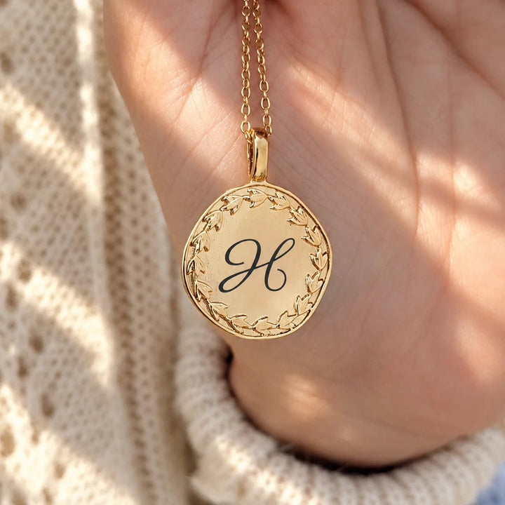 Collier personnalisé médaille acier mat doré gravée initiale H, port main femme